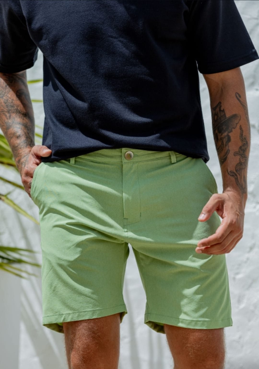 Detalle de bermuda de tactel color pistacho con remera negra